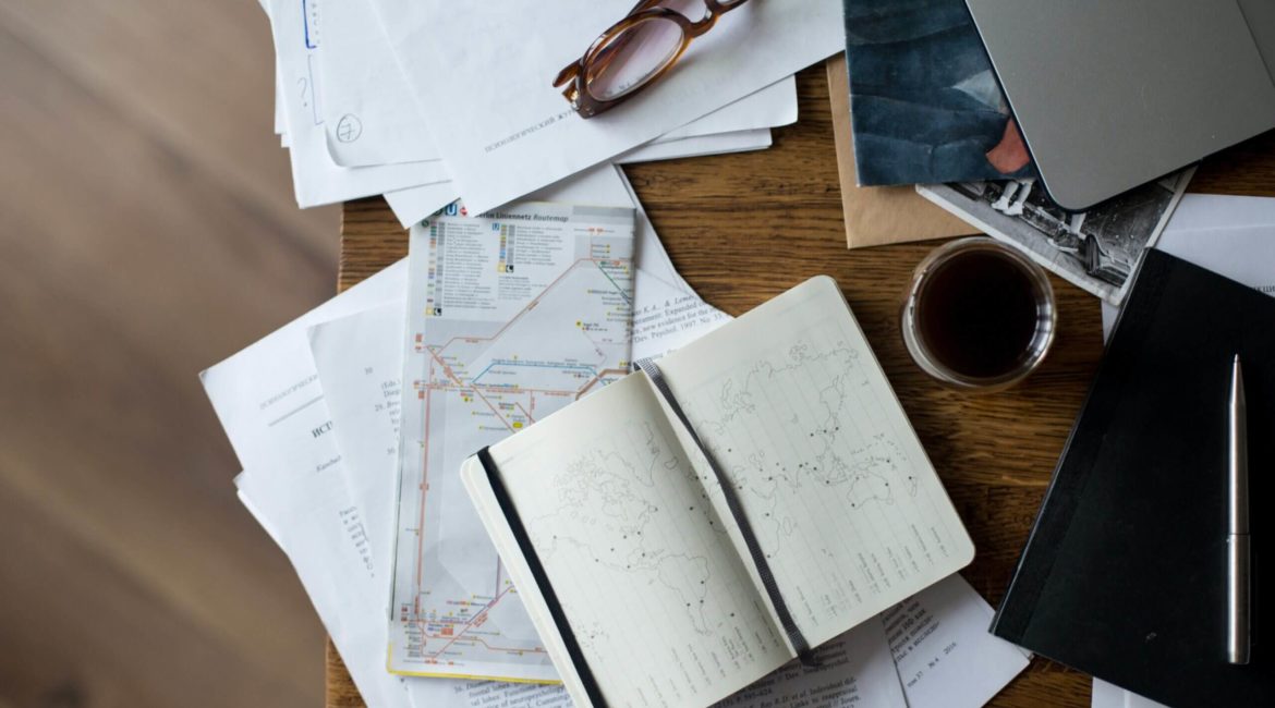 Maps, documents and laptop on a desk